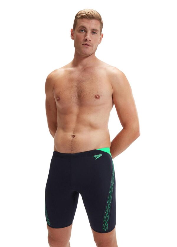 Homem com as mãos atrás das costas usando Speedo HyperBoom Splice Jammer - Marinho / Verde